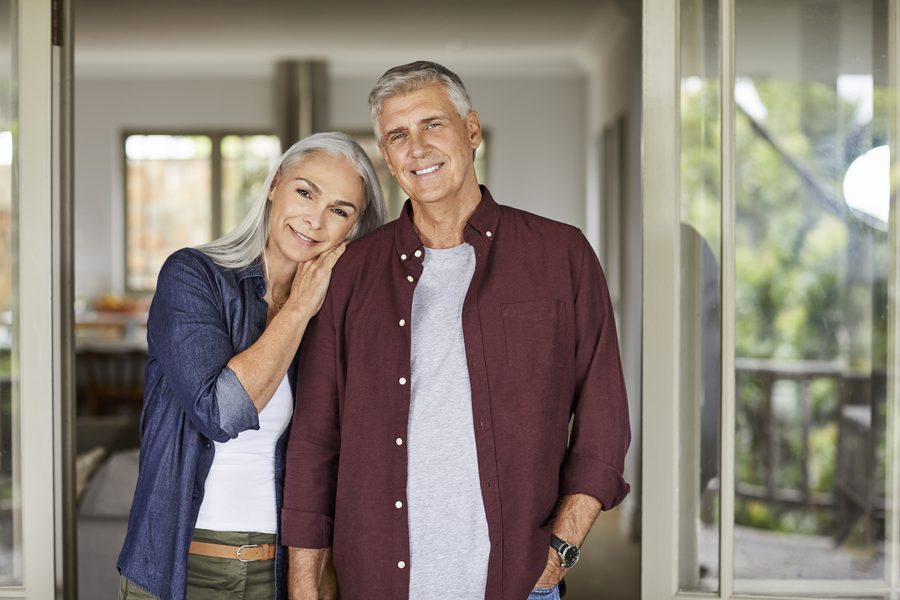Happy older couple standing side by side smiling